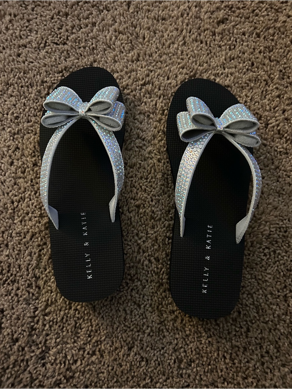 Kelly & Katie Black Flip Flops with Iridescent Silver Bow